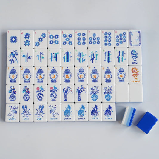 A close-up jumbled view of the Chinoiserie Porcelain American Mahjong tiles.webp, highlighting the ice blue layered sandwich core, hand-painted details, and solid deep blue backs.