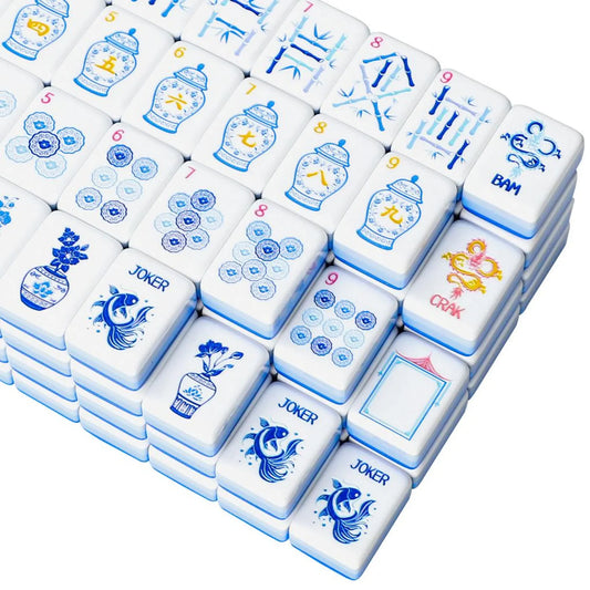 Close-up corner view of stacked porcelain style Mahjong tiles showcasing koi fish jokers, blue medallion dots, and gold dragon tiles.