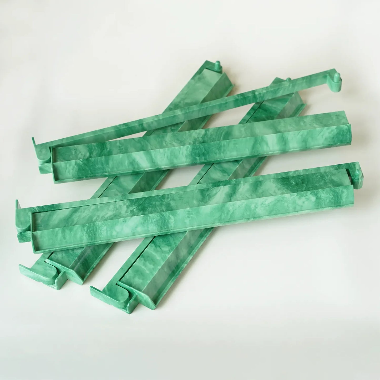 Set of four 17.5-inch green swirl patterned mahjong racks with attached pushers.